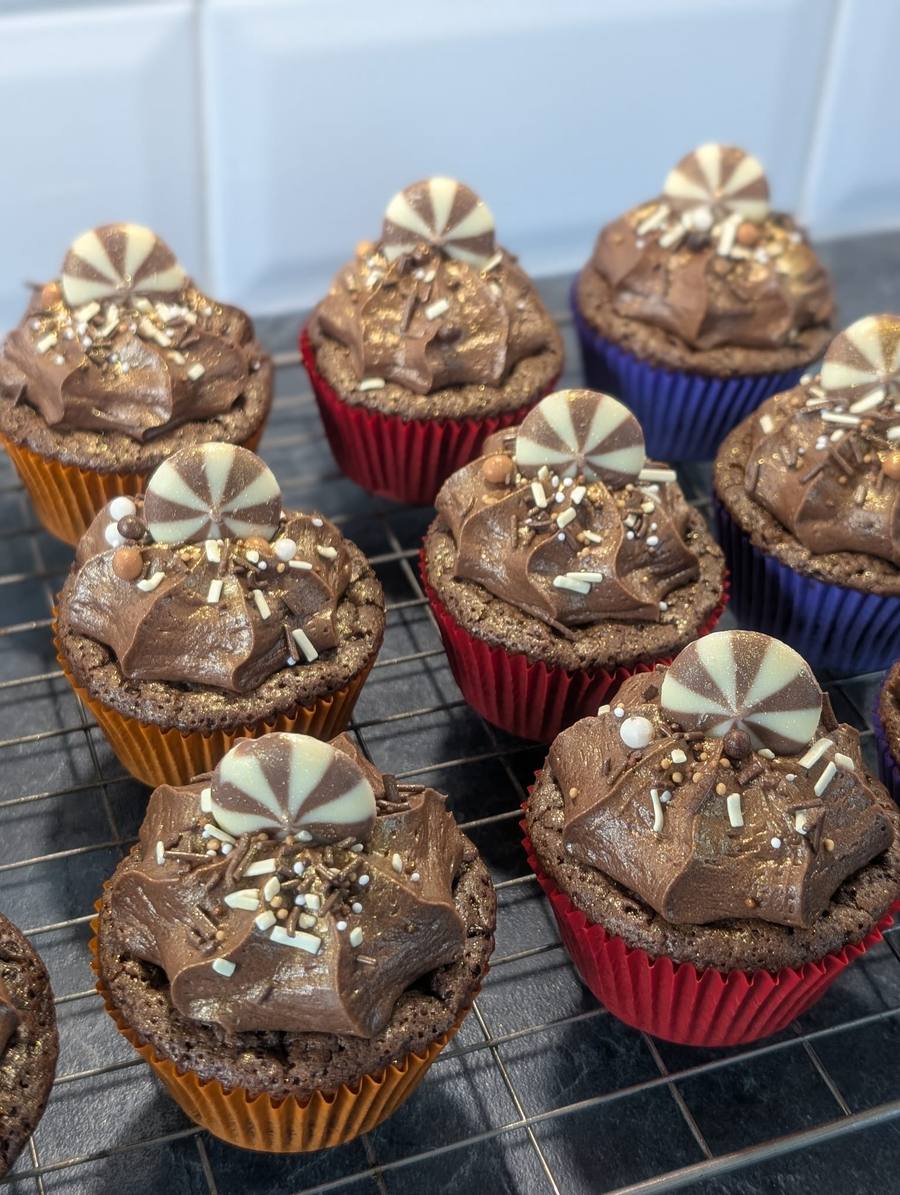 Chocolate cupcakes topped with a chocolate pinwheel and sprinkles